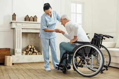 caregiver assisting senior man to stand