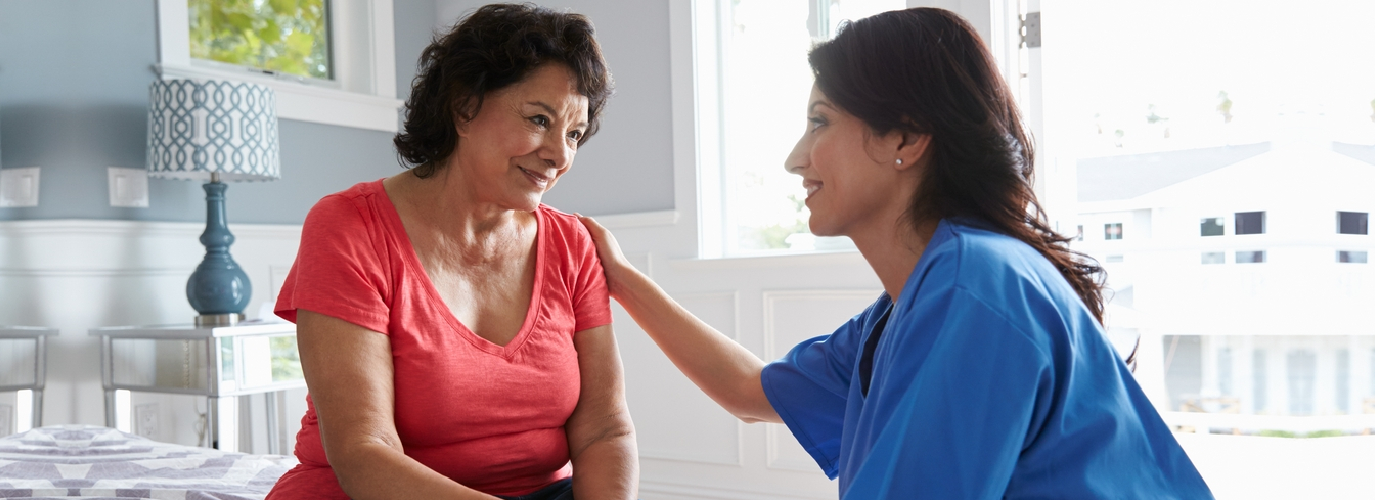 senior woman and caregiver smiling