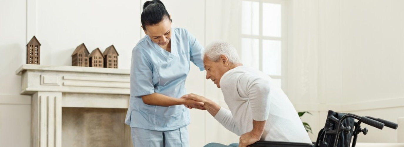 caregiver assisting senior man to stand